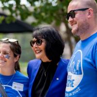Two Alumni standing with President Mantella.